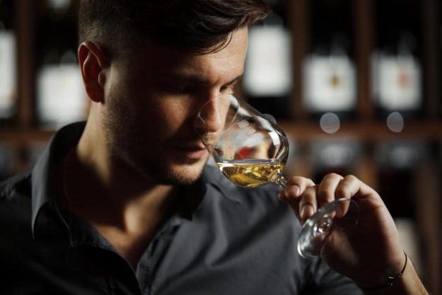 Weinprobe Salzburg – Mann trinkt Weißwein